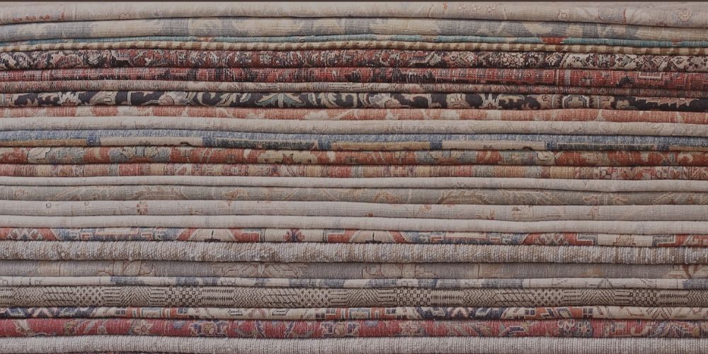 Stack of handmade rugs in the Rugs of Petworth showroom