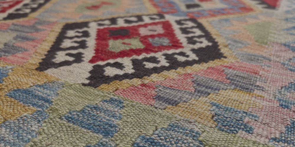 Close-up of a handwoven Kilim flatweave rug showing geometric pattern and texture