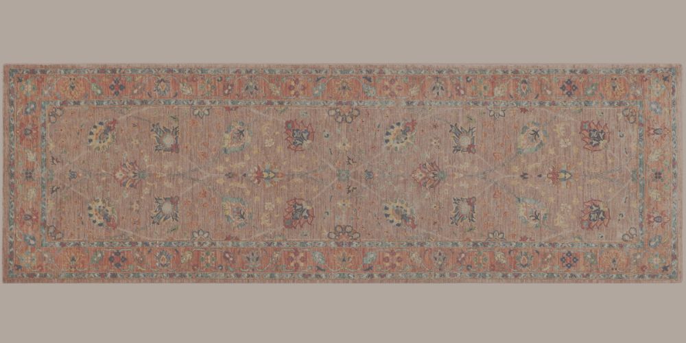Hand-knotted wool runner rug with a soft floral design in muted terracotta and blue tones.